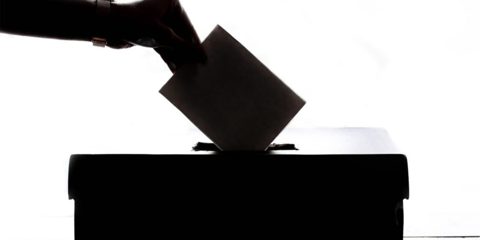 Person putting a vote into a box.