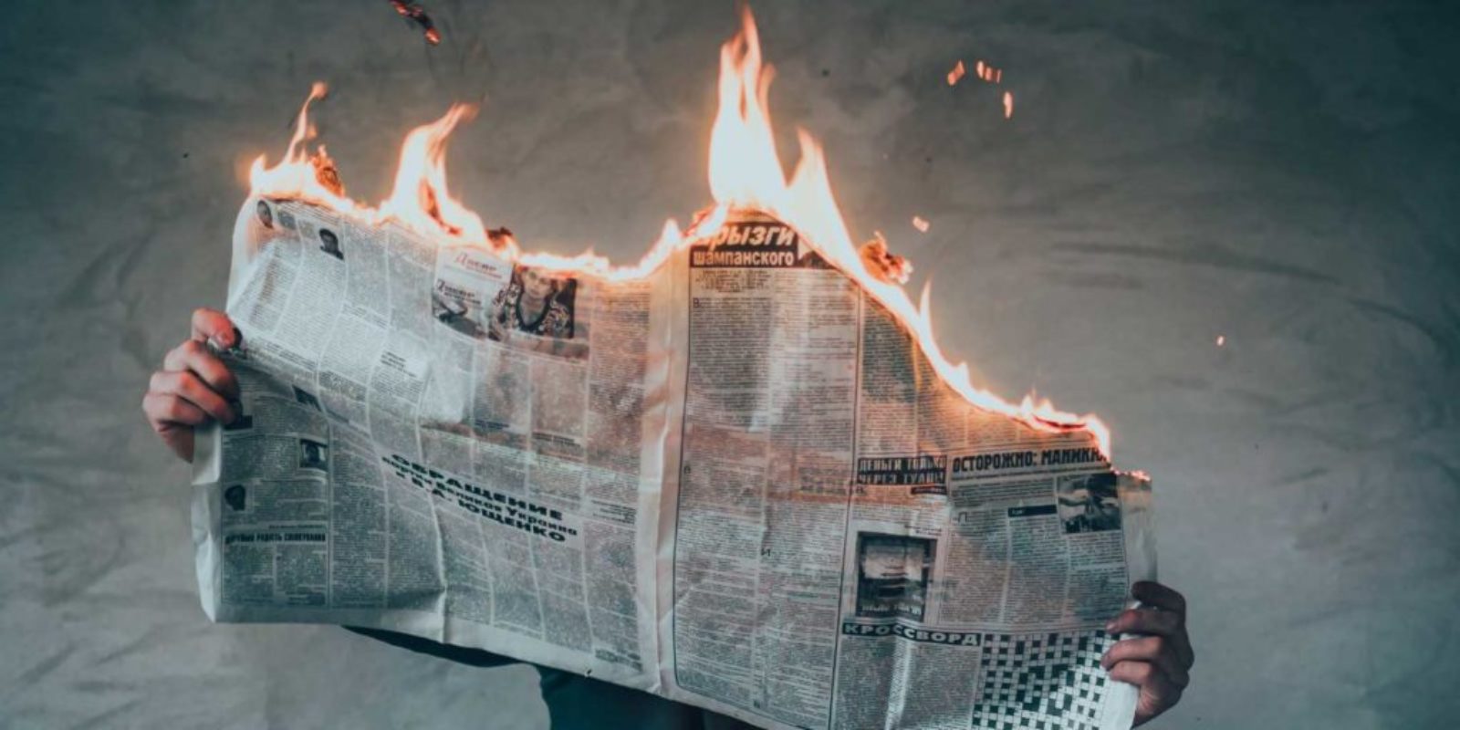 Newspaper burning while a person is reading it.